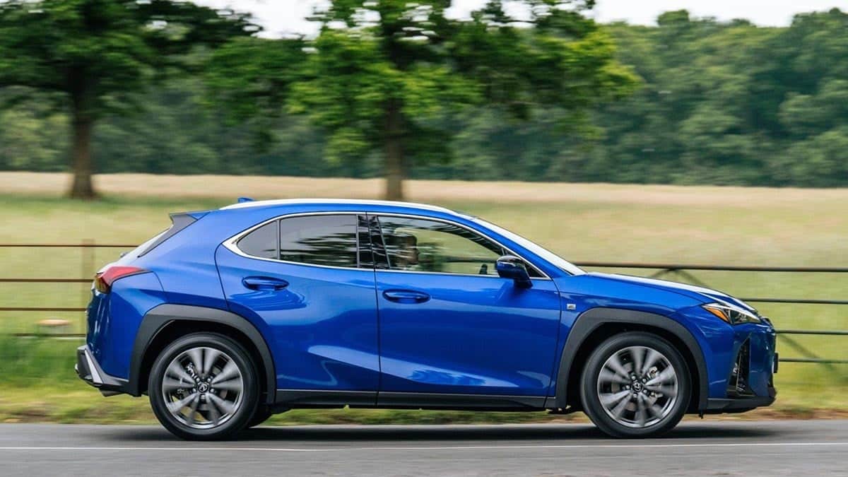 Side view of the 2026 Lexus UX hybrid in Urban trim on open road