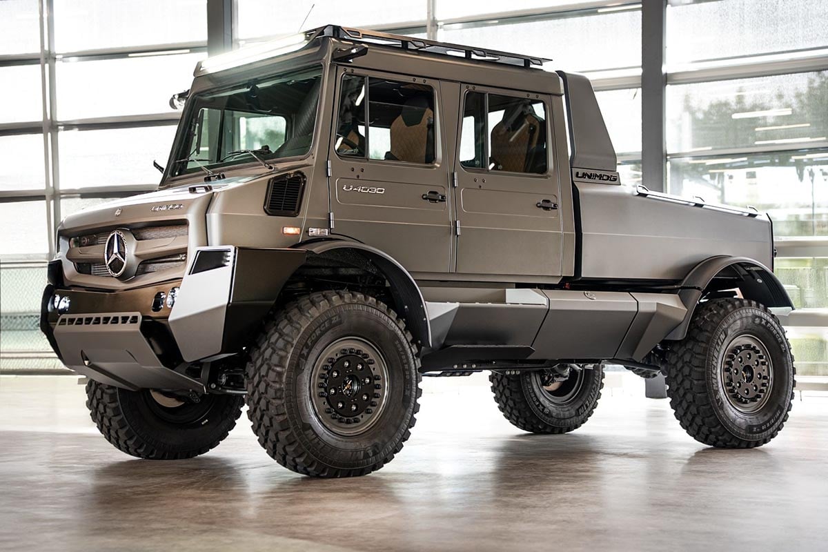 Vue latérale du Mercedes Unimog 4030 sur un terrain rocheux, peinture mate et pneus tout-terrain