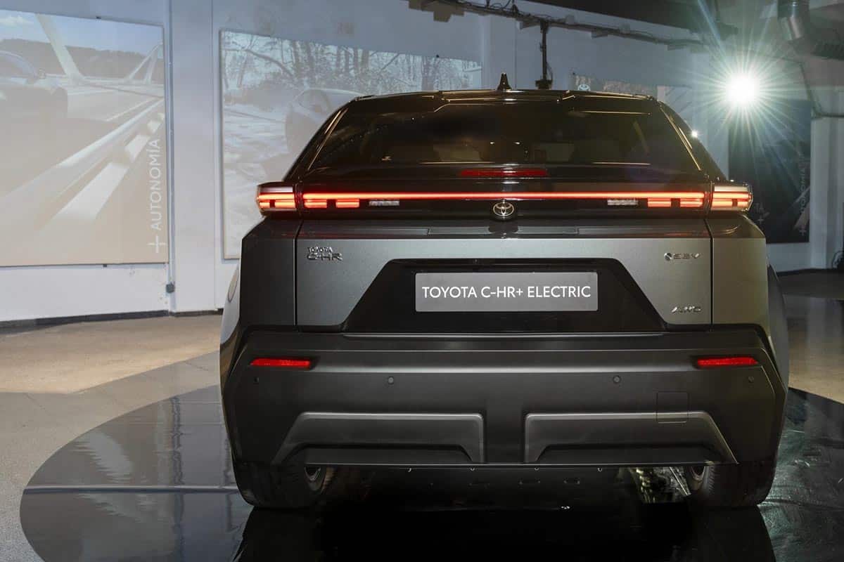Vue arrière du Toyota C-HR+ avec barre lumineuse, aileron intégré et logo central